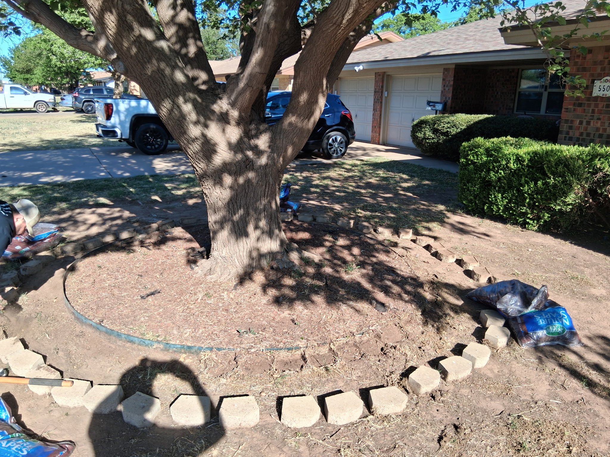 Stone border tree ring being built around a front yard tree in Lubbock, TX