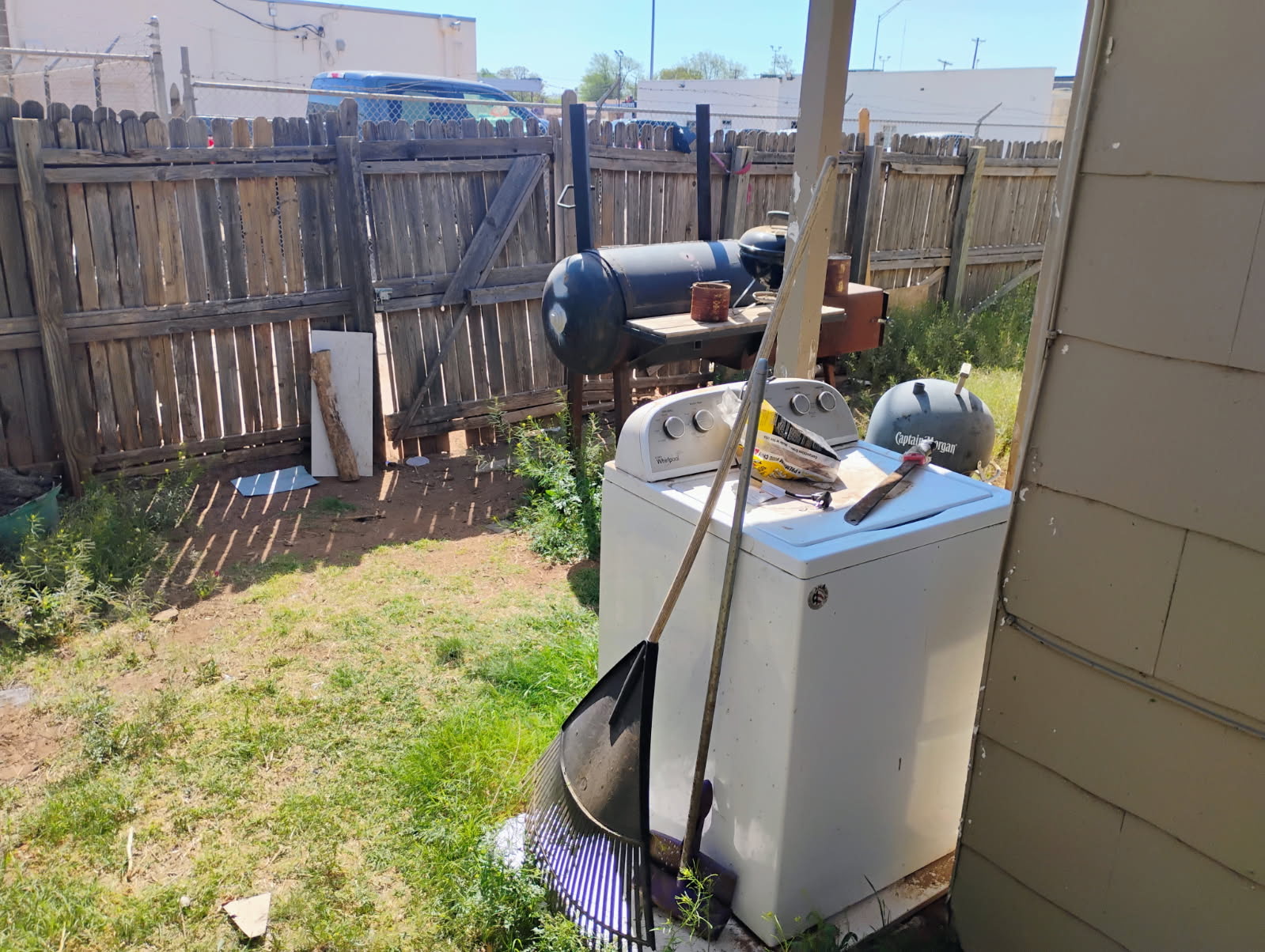 Backyard with weeds and clutter before cleanup by 3D Landscaping in Lubbock, TX